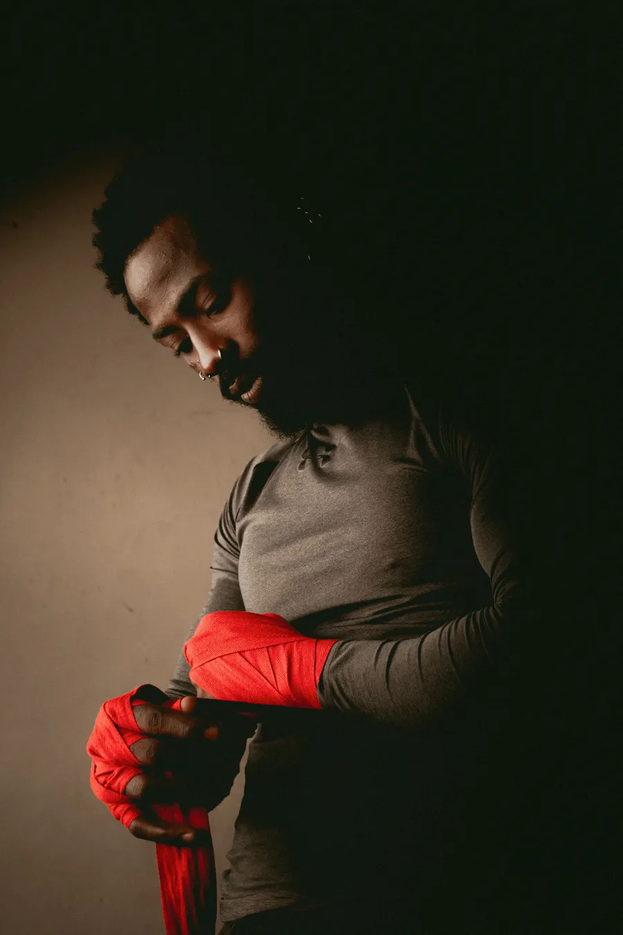 Combattant qui enroule ses bandes de boxe en clair obscur