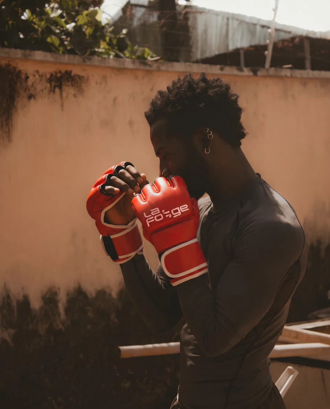 Combattant en garde avec des gants de MMA rouges au logo La Forge