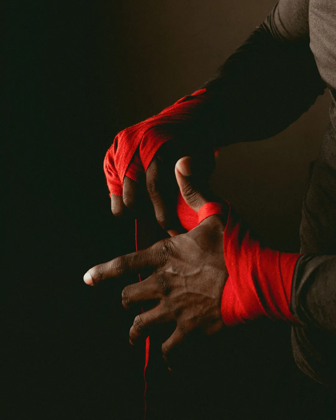 Mains enroulant des bandes de boxe rouges, visuel de campagne La Forge