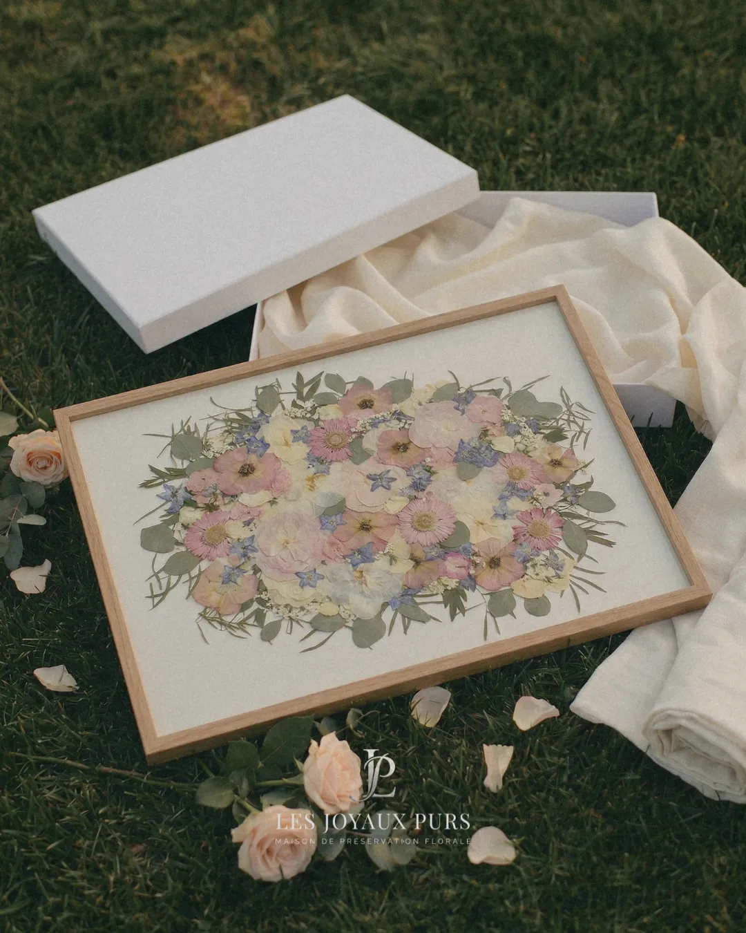Cadre de fleurs de mariage préservées posé sur son coffret, direction artistique Studio Falida