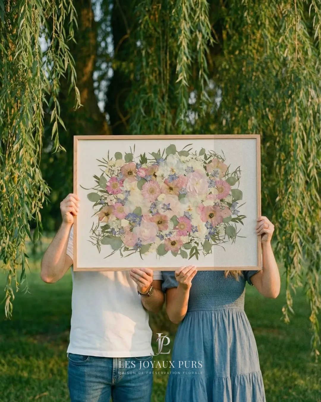 Couple cachant son visage derrière le cadre de fleurs préservées