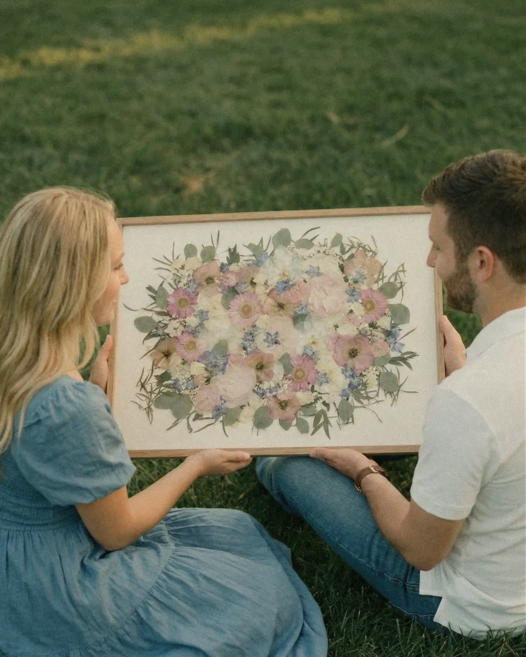 Couple tenant son tableau de fleurs préservées, campagne Les Joyaux Purs